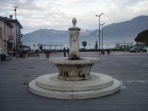fontana di piazza mercato con lo sfondo del lago d’iseo
