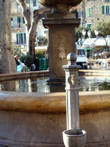 La fontana nella piazza che riflette il Borgo e il Castello Doria