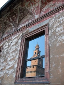 La Torre del Filarete si specchia in una finestra del Castello Sforzesco