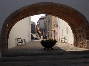 Un arco, due panchine e una fioriera