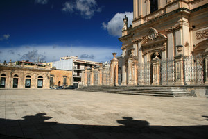 Piazzale con colonnato e chiesa con cancellata