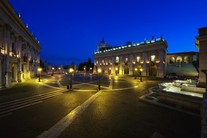 Gli edifici che divergono nella piazza ovale e la fontana illuminata