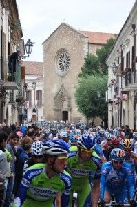 Ciclisti in corsa con la Chiesa di S. Francesco a Lucera (FG)
