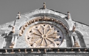 Rosone e sculture a colori sul b/n della facciata della cattedrale